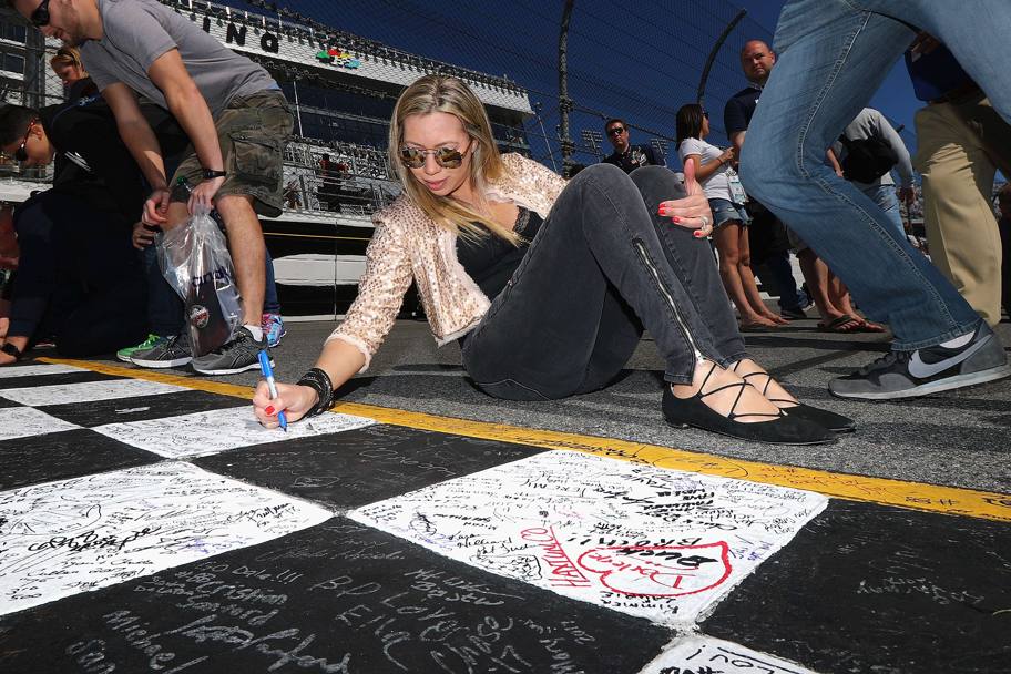 Un’appassionata di gare automobilistiche appone la propria firma sulla linea di partenza del circuito di Daytona (Afp)